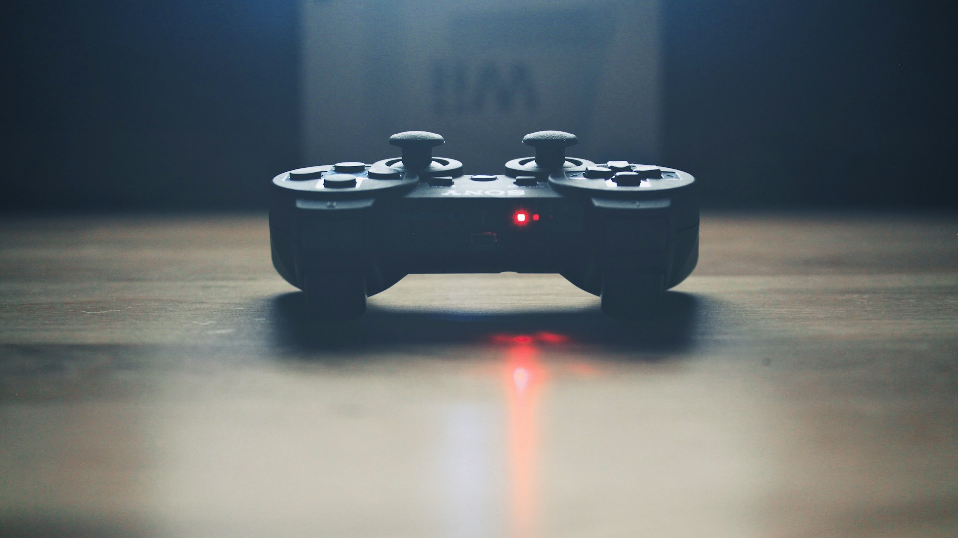 Gaming desk lit in spearmint neon inside a concrete loft studio
